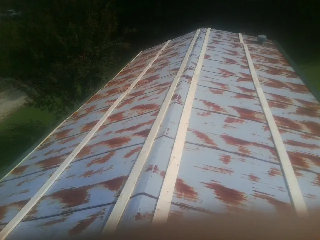 Rusted metal roof panels with new wood purlins before replacement — Storm Damage Roof Repair in Sunbright by Roofing Brothers