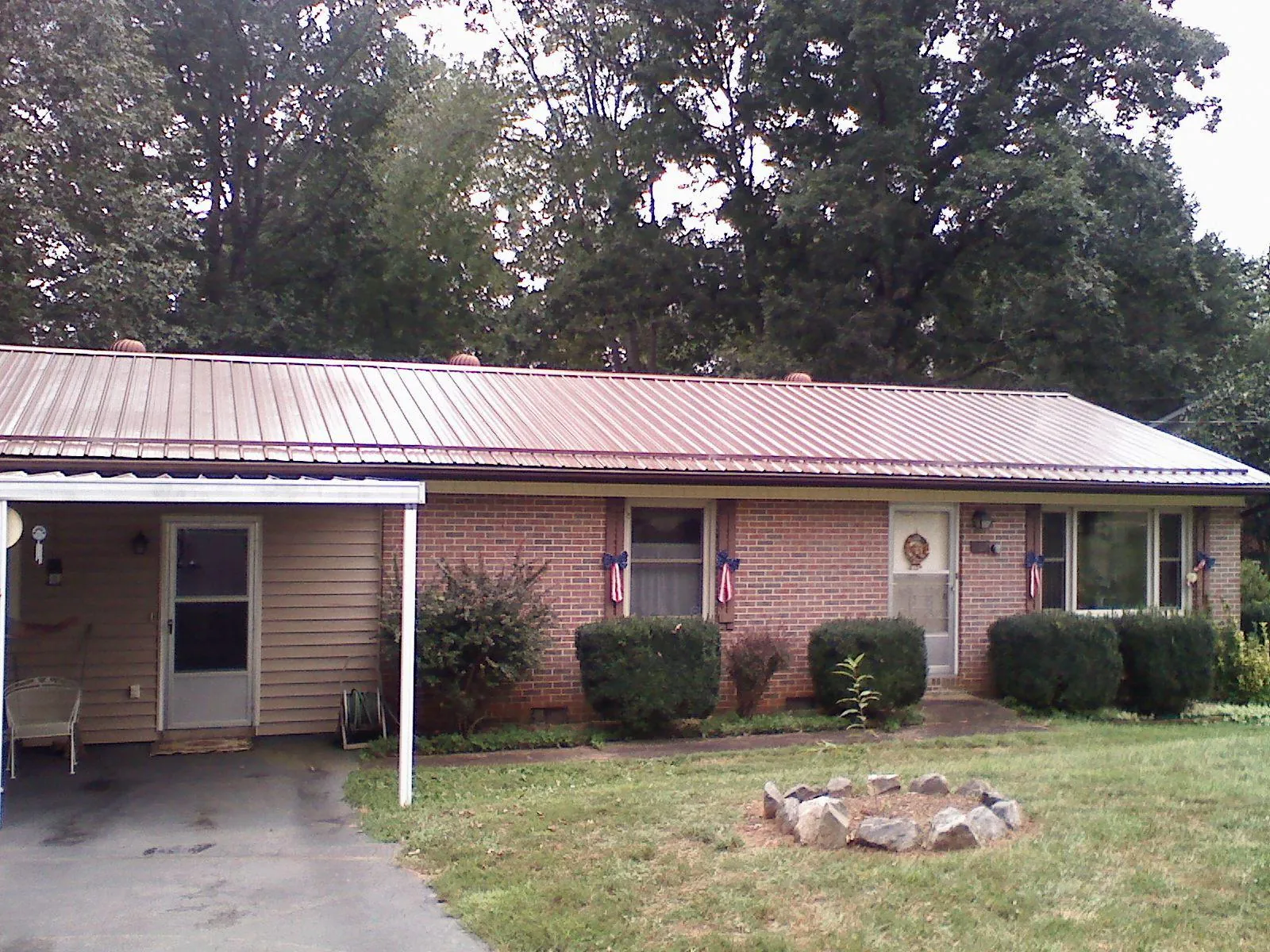 Bronze metal roof and carport on a brick ranch home — Roof Repair work by our crew in Sunbright