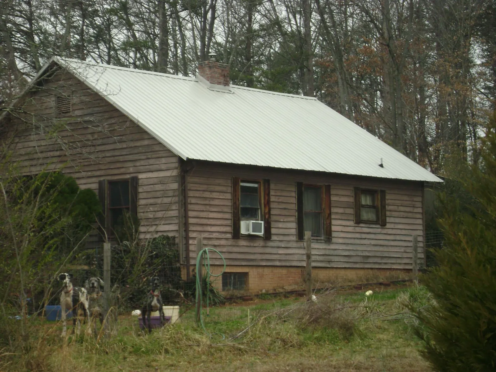 White metal roof on an old wood sided farmhouse, from a Metal Roof Installation job in Sunbright